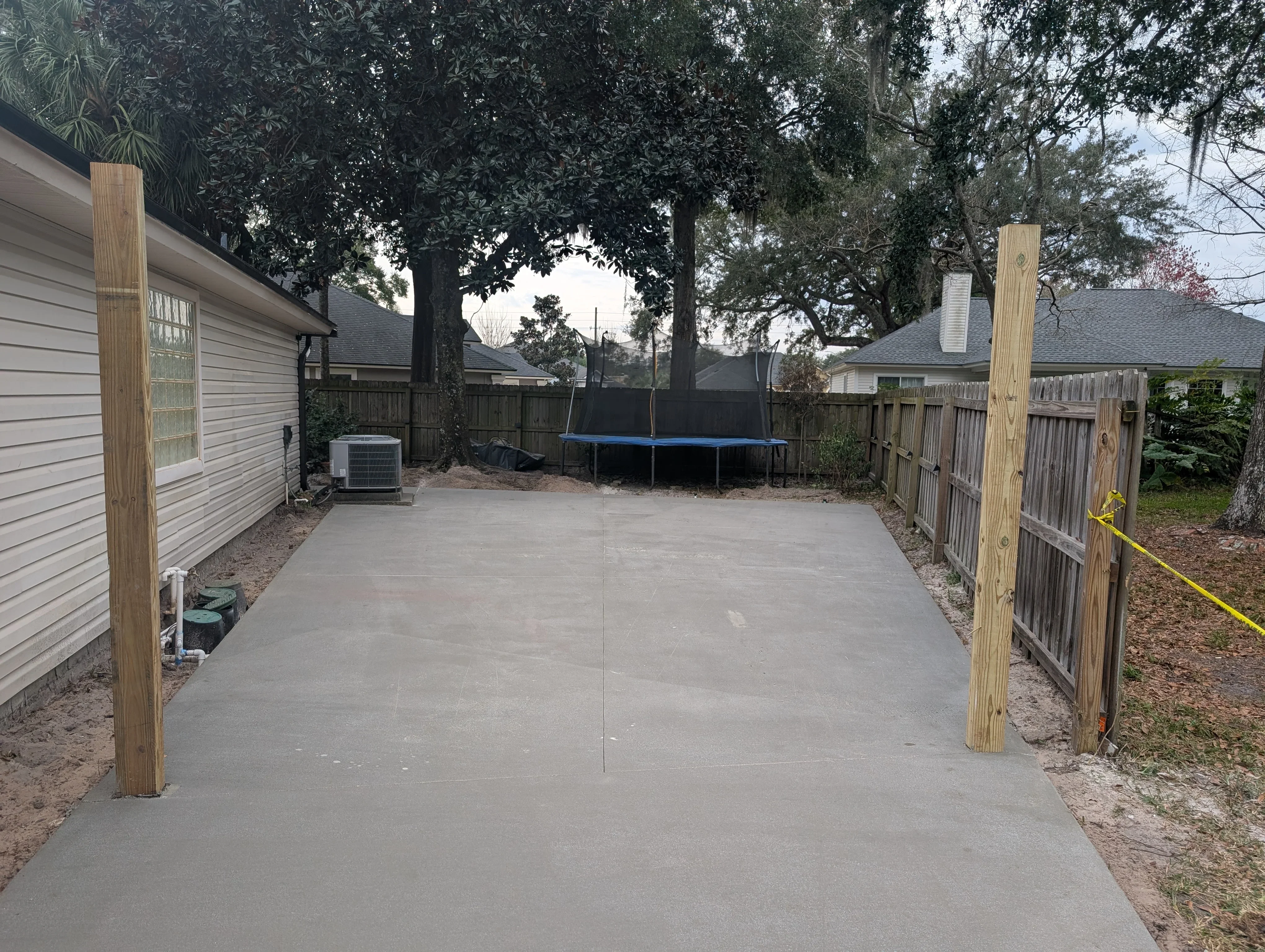 Finished concrete pad with control joints, wood post supports, and wooden fence borders