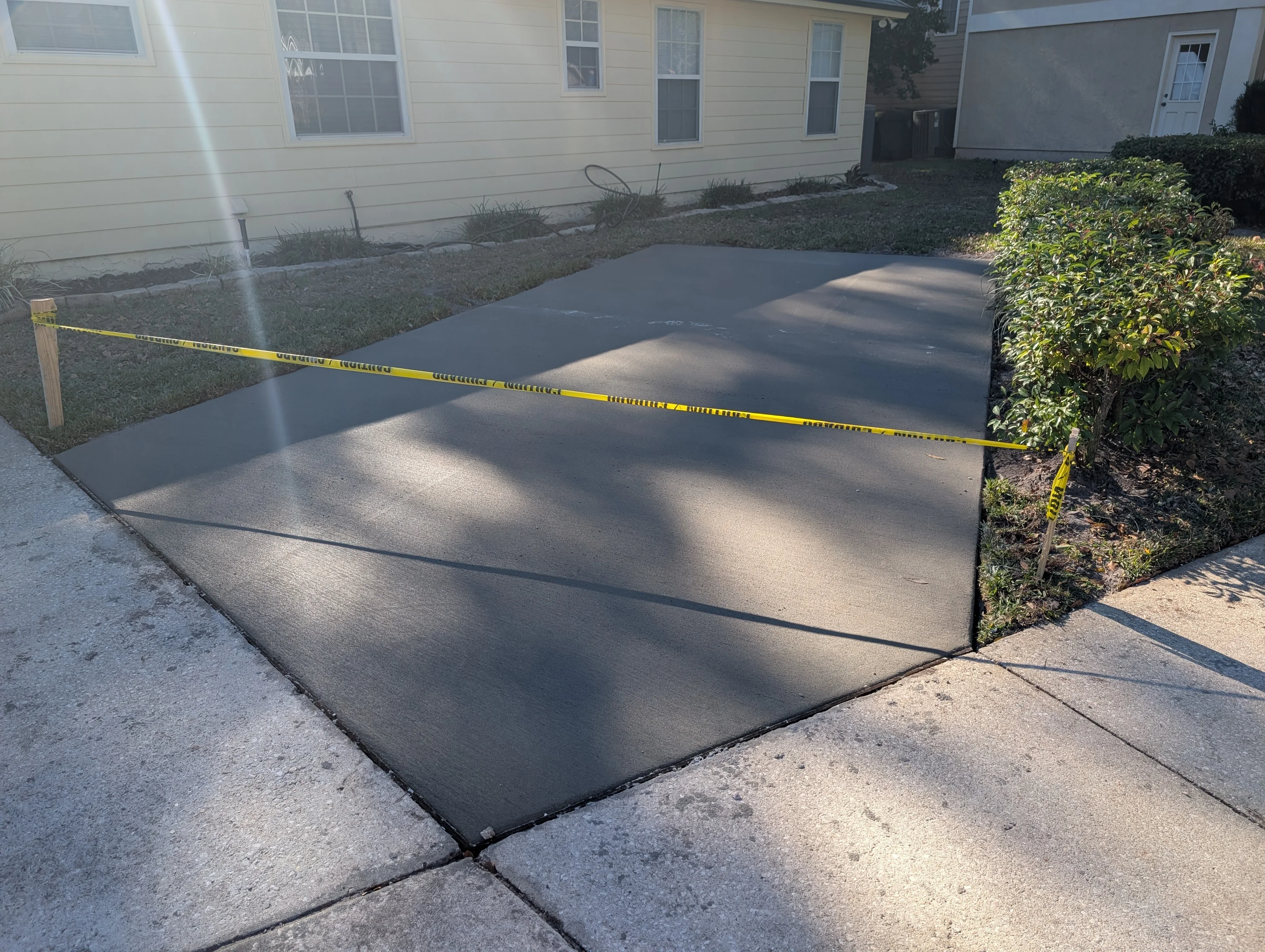 Newly poured concrete driveway with control joints and finished surface