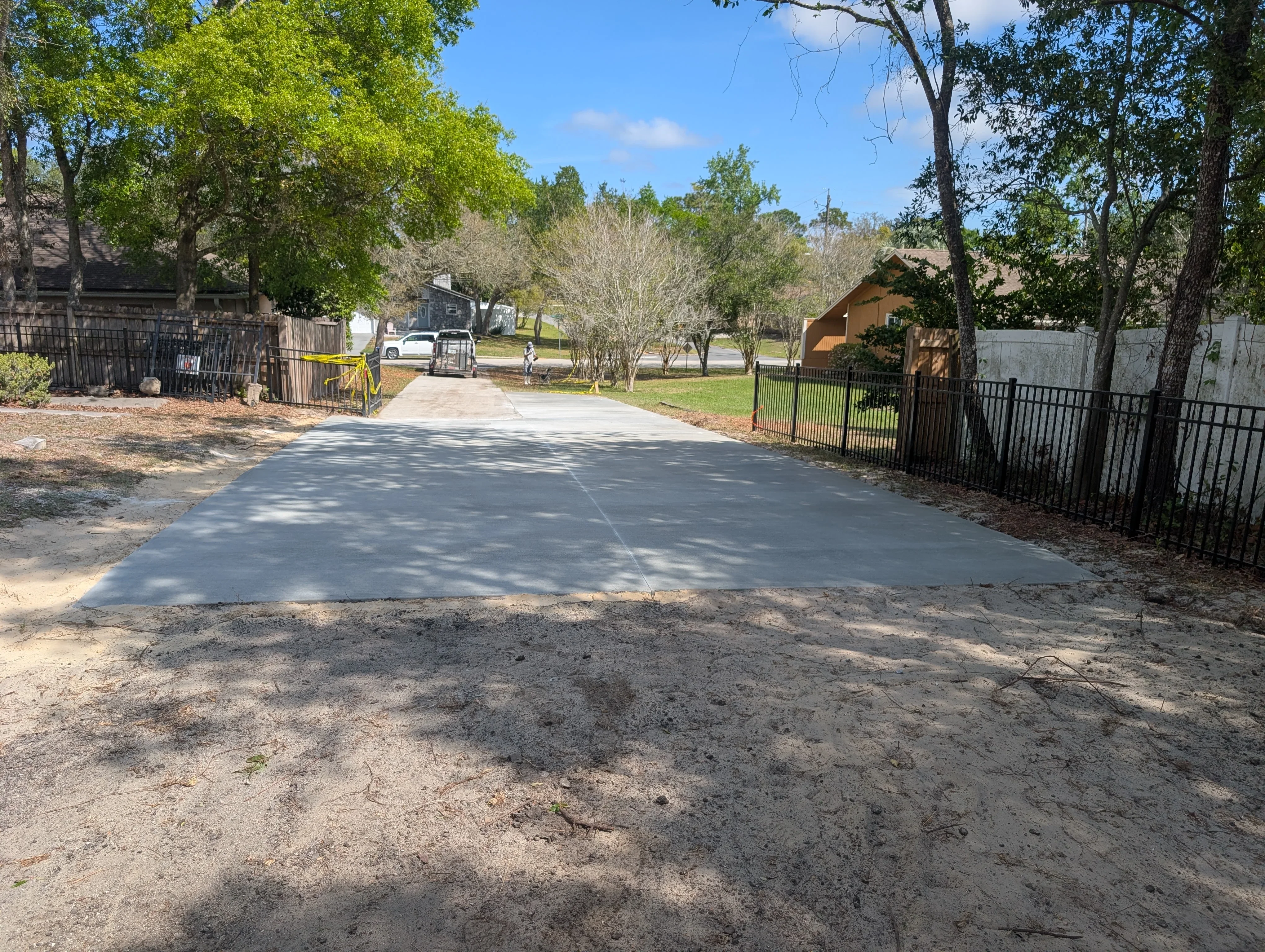 Newly poured concrete driveway with finished surface and compacted base in residential property